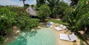 an overhead view of a swimming pool with chairs and trees at Phinisi Villas - Seminyak Beach in Seminyak