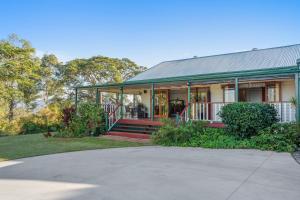 a house with a porch and a driveway at Amamoor Homestead and Country Cottages in Amamoor