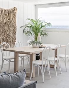 une salle à manger blanche avec une table et des chaises dans l'établissement Swell Kiama, à Kiama