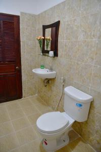 La salle de bains est pourvue de toilettes et d'un lavabo. dans l'établissement Thatsaphone Hotel, à Luang Prabang