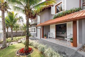 - une vue sur l'extérieur d'une maison avec des palmiers dans l'établissement Casa Paradisíaca na Lagoa da Conceição, à Florianópolis