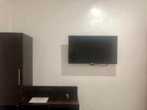 einen Flachbild-TV, der an einer Wand hängt in der Unterkunft Paguia’s Cottages in Mambajao