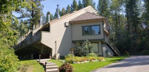 a house with a porch and flowers in front of it at Akiskinook Resort on Lake Windermere - 1 Bedroom Condo - Sleeps 4 - Indoor Pool - Hot Tub - Sandy Beach - Hot Springs - Golf - 12 Courses - Walk to Town - Shopping - Dining - Local Pubs in Invermere