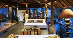 a living room with two beds and a couch and tables at The Purist Villas & Spa Ubud in Ubud +153 photos