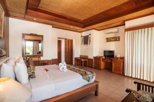 a bedroom with a large bed and a television at Sri Phala Resort & Villa in Sanur