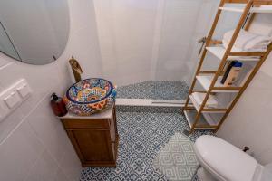 uma casa de banho com um WC, um lavatório e um espelho. em Loft Turfa em Tbilisi
