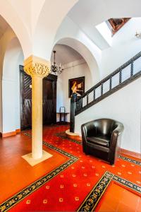 a living room with a black leather chair and a red rug at Vila Leonida - RESORT LEONIDA in Buşteni