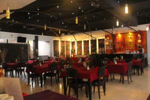 a restaurant with red tables and chairs in a room at The Radiant Hotel in Kuta