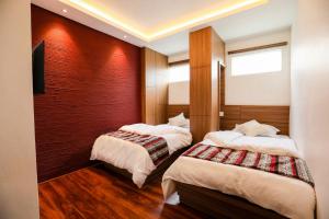 una camera d'albergo con due letti e una televisione di Flying Yak Kathmandu a Kathmandu