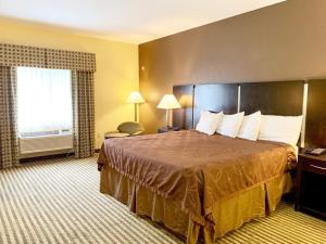 um quarto de hotel com uma cama grande e uma janela em Whitney Inn & Suites em Hamden