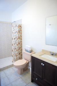 La salle de bains est pourvue de toilettes, d'un lavabo et d'une douche. dans l'établissement Casa Loritos, à Cancún