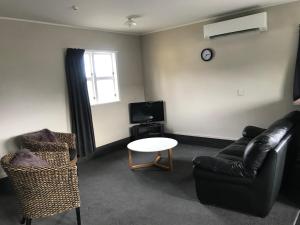 a living room with a couch and a table and a tv at Twizel Holiday Park in Twizel