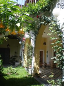 un arco en un jardín con flores y plantas en La Baronessa B&B, en Riposto