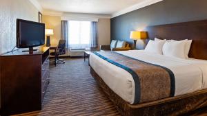 um quarto de hotel com uma cama e uma televisão de ecrã plano em Best Western Augusta West em Augusta
