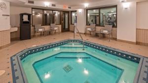 a pool in a hotel room with chairs and tables at Best Western Airdrie in Airdrie