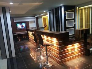a bar with two chairs and a television in a room at I Garden Place in Ban Choho