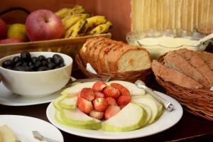 a table topped with plates of fruit and bread at Kasthamandap Boutique Hotel in Kathmandu