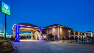 ein Hotel mit einem blau beleuchteten Parkplatz in der Unterkunft SureStay Hotel by Best Western Terrell in Terrell