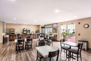 ein Restaurant mit Tischen und Stühlen und eine Bar in der Unterkunft MainStay Suites Cedar Rapids North - Marion in Cedar Rapids