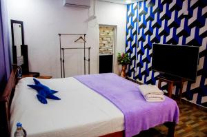 a bedroom with a large bed and a tv at Hotel Chanaya in Ambanpola