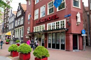 un edificio en una calle con gente caminando delante de él en Avenue Hotel en Ámsterdam