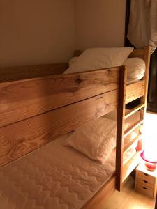 a wooden bunk bed with white pillows on it at Studio Monêtier-les-Bains (Serre Chevalier) in Le Monêtier-les-Bains