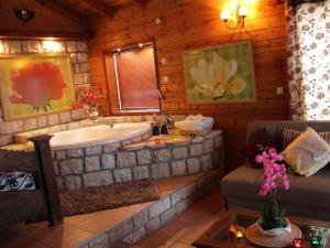 bagno con vasca e divano. di First Light Cabins ad Amirim