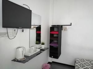 ネゴンボにあるHouse of Seyaのテレビ、棚(タオル付)が備わる客室です。