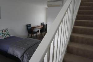 a bedroom with a bed next to a staircase at Ashmont Motel and Apartments in Port Fairy