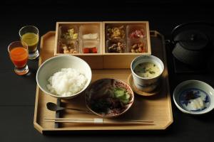 Hotel Koo Otsuhyakucho في أوتسو: صينية مع أطباق من الطعام والمشروبات على طاولة