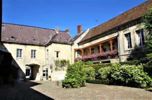 an old building with flowers in a courtyard at Hôtel Le Régent in Villers-Cotterêts
