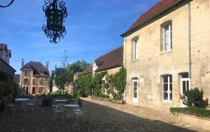 a cobblestone street with tables and chairs next to a building at Hôtel Le Régent in Villers-Cotterêts