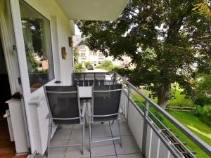 einen Balkon mit 2 Stühlen und einem Tisch in der Unterkunft Fewo E am Kurpark in Willingen