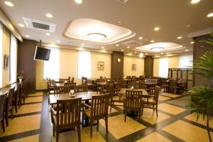 a restaurant with tables and chairs and a flat screen tv at Hotel Route-Inn Noshiro in Noshiro