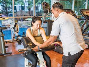 a man and a woman riding on a exercise bike at Hard Rock Hotel Pattaya - SHA Extra Plus in Pattaya