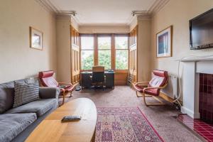 ein Wohnzimmer mit einem Sofa und einem Kamin in der Unterkunft 3 bed overlooking meadows park in Edinburgh