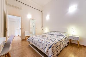 a white bedroom with a bed and a table and chairs at La Corallina in Santa Margherita Ligure