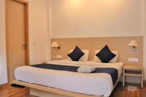 a bedroom with a large bed with black and white pillows at The Blue Jay Hostel in Rishīkesh +54 photos