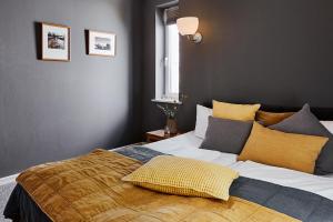 una camera da letto con un grande letto con cuscini gialli e grigi di STAY Boardinghouse Flottbek ad Amburgo