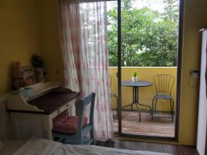 Schlafzimmer mit einem Balkon mit einem Tisch und Stühlen in der Unterkunft Sweet Home 101 in Guangfu