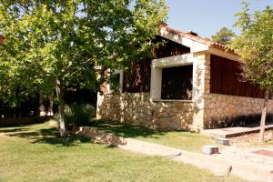 a stone house with a window in a yard at Aventura & Relax Cabañas Peña la Higuera in Villalba de la Sierra