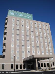a large building with a sign on top of it at Hotel Route-Inn Seki in Sekimachi
