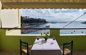 a table with a view of the ocean from a window at Haravgi Hotel in Patitiri