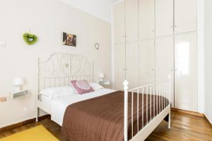 een slaapkamer met een wit bed en een bruine deken bij Beautiful appartment under Akropolis! in Athene