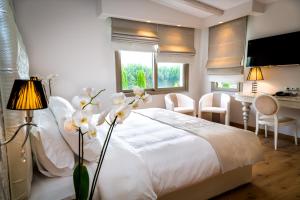a bedroom with a white bed with a table and chairs at Calma Hotel & Spa in Kastoria