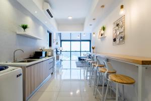eine Küche mit einer Bar mit Hockern in der Unterkunft PROMO!Emerald Green Stylist Duplex 8min to Sunway in Petaling Jaya
