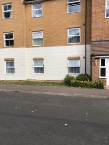 an empty street in front of a brick building at Modern Flat in Watford