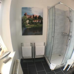 baño con ducha y 2 sillas blancas en Bilderbuchcafe - Ferien - Apartment NO 3 - Markt 7, en Havelberg