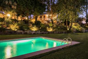 a swimming pool in front of a house at night at Torrinheira ~ Family Pool Villa and Woods in Travanca