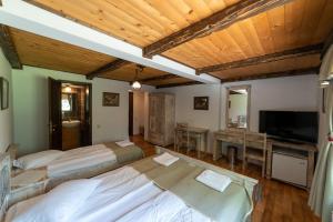 a large room with three beds and a television at Arcso Fogado in Corund